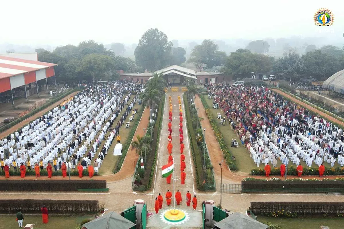 The grounds of Divya Dham Ashram from above on Republic Day 2023, devotees in white along a tree-lined path